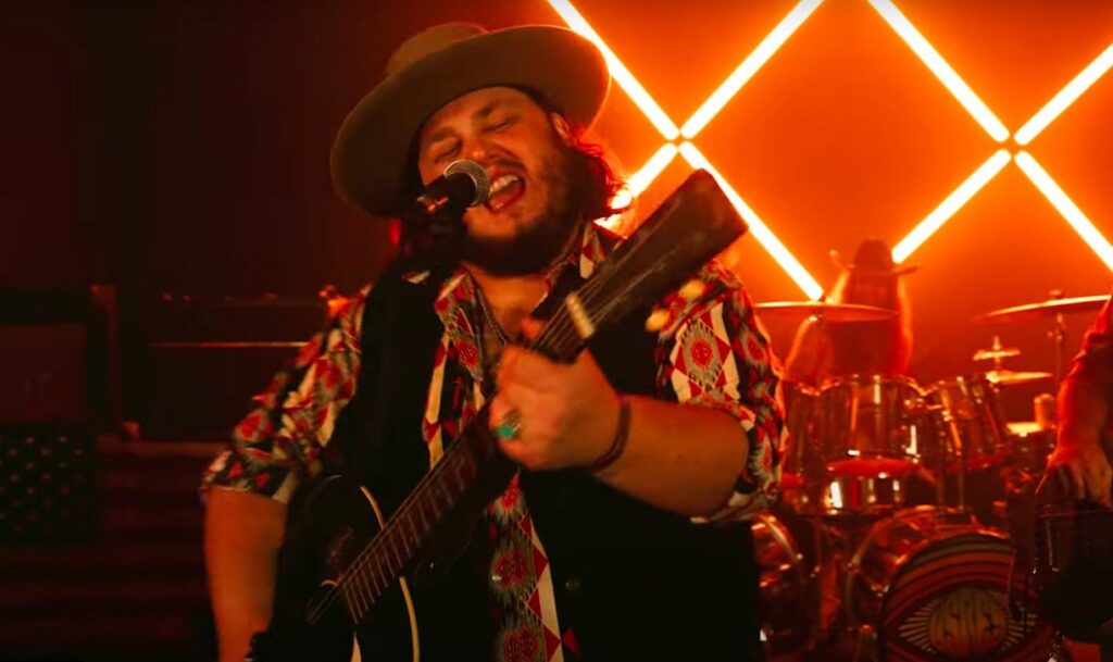 A passionate performance by a Southern rock artist Tanner Usrey under stage lights, capturing the bold spirit of music in Landman.