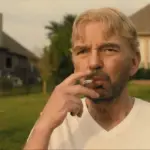 Tommy Norris smokes outside his suburban home, deep in thought, reflecting on sacrifice, power, and freedom in Landman.