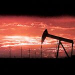 Texas oil pump silhouetted against a fiery sunset, evoking the dramatic backdrop for a potential Landman prequel set in the 1980s.