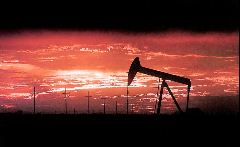 Texas oil pump silhouetted against a fiery sunset, evoking the dramatic backdrop for a potential Landman prequel set in the 1980s.